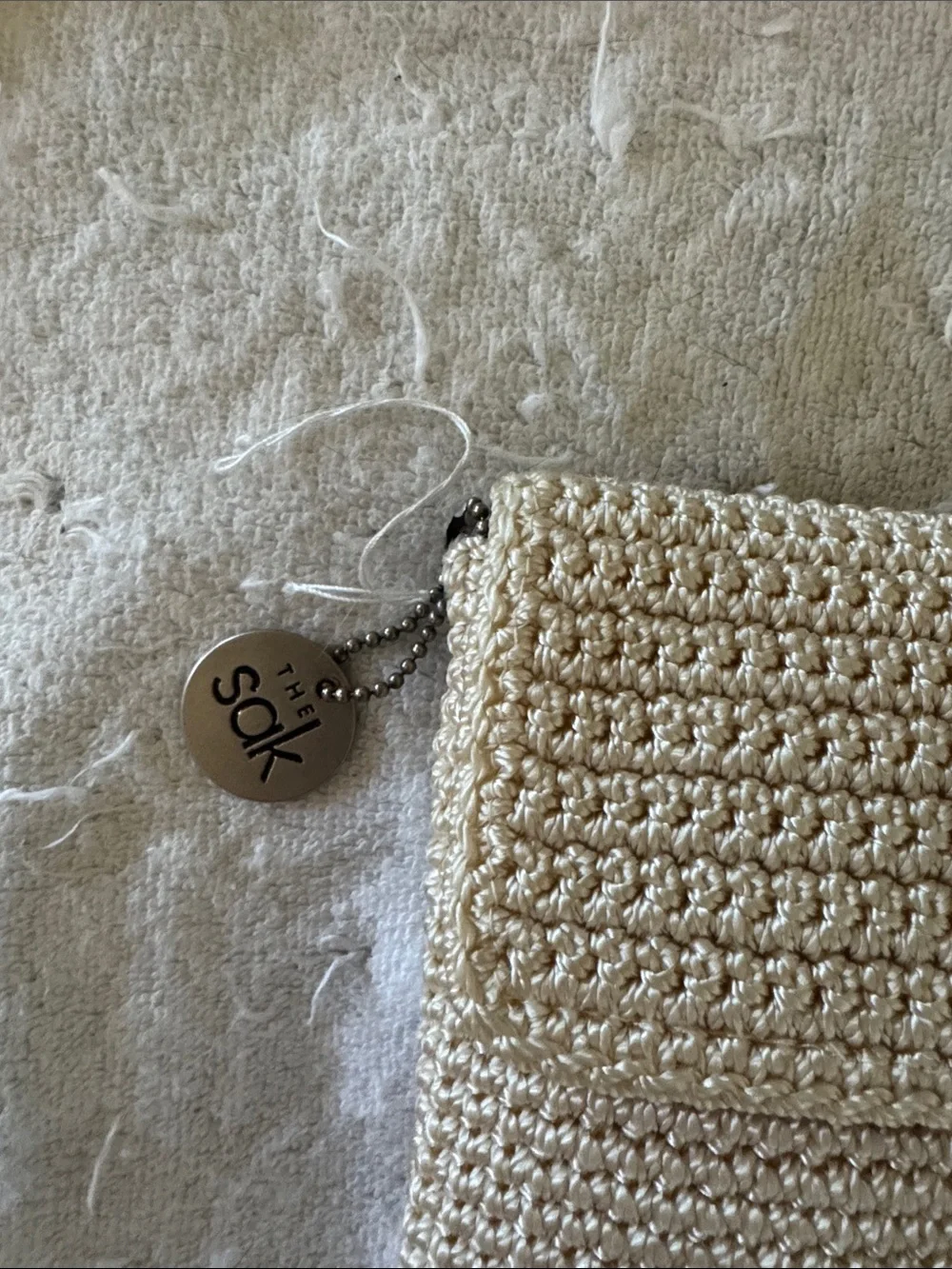 NWOT, The Sak crochet zip pouch in creme .
